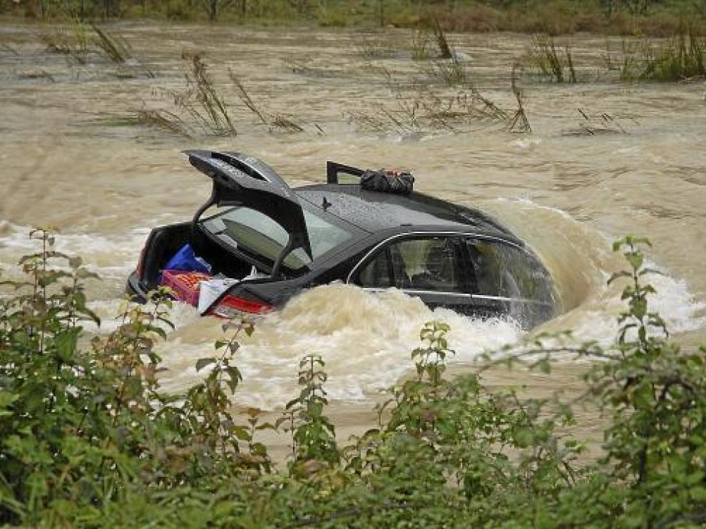La mujer fue arrastrada con su coche -en la foto- al cruzar el río por un vado. Fue rescatada ilesa.