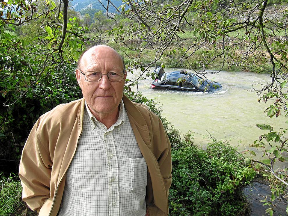 Juan José Urquizu, de 74 años, posa delante del coche, todavía atrapado, de su amiga Carmen