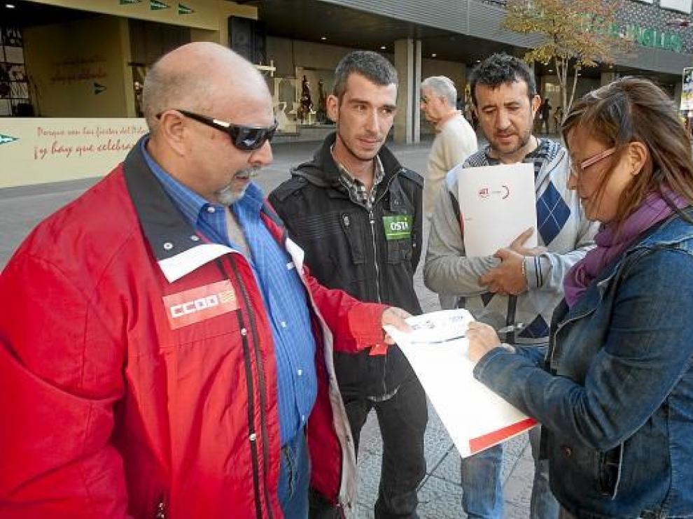 Representantes de CC. OO., OSTA y UGT informan de su campaña a una ciudadana.