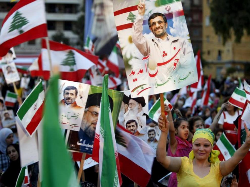 Un grupo de manifestantes libanesas reciben a Mahmud Ahmadineyad con banderas nacionales e iraníes