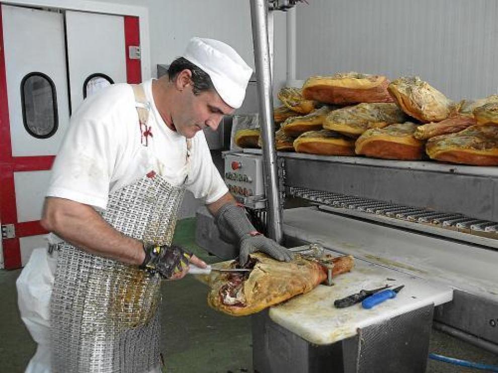 Un operario trabaja en la empresa de deshuesado Servijamón.