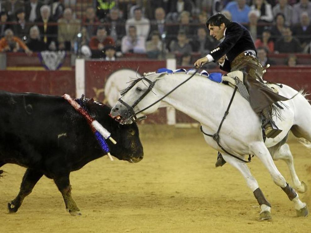 Momento culminante de la faena de Diego Ventura montando al caballo Morante, el tordo en fase blanca, que muerde a los toros.