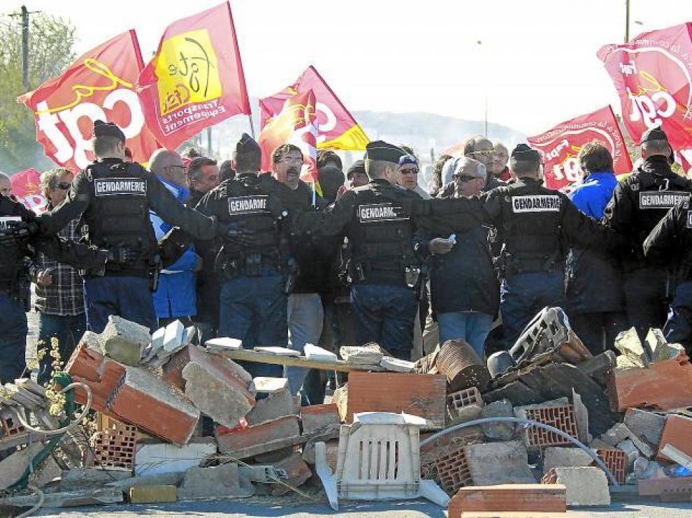 Policías franceses se enfrentan a los trabajadores que bloquean el acceso a la refineria de Frontignan-la-Peyrade, ayer.