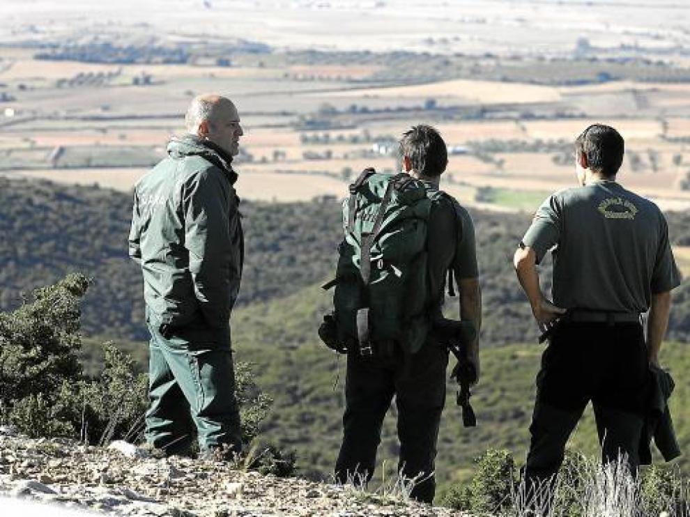 Tres agentes divisan desde el cortado el inmenso y denso terreno que hay bajo el Salto de Roldán.
