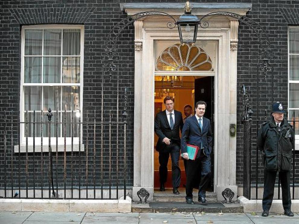 El ministro de Economía, George Osborne (d), y el secretario del Tesoro, Danny Alexander, salen del número 10 de Downing Street.