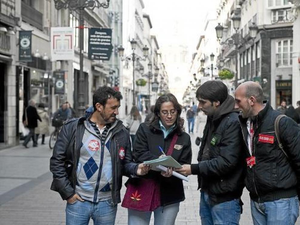 Miembros de UGT, OSTA y Comisiones recogen la firma de una ciudadana en el centro.