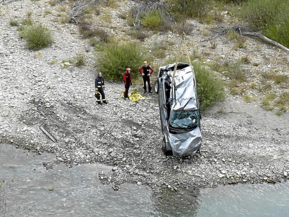 Momento en el que una grúa saca del Gállego el vehículo en el que viajaban las víctimas y que se precipitó al vacío unos 20 metros.