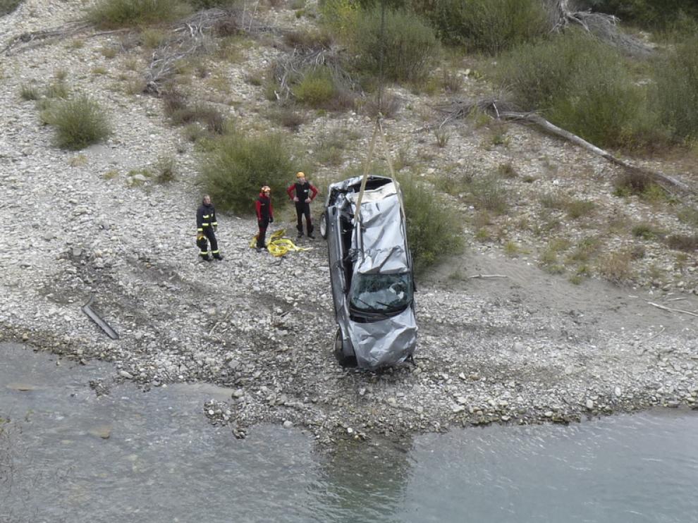 Momento en el que una grúa saca del Gállego el vehículo en el que viajaban las víctimas y que se precipitó al vacío unos 20 metros