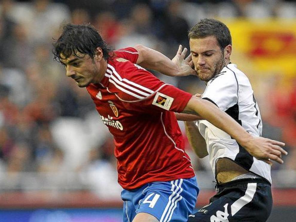 Contini saca la pelota, presionado por el valencianista Mata.