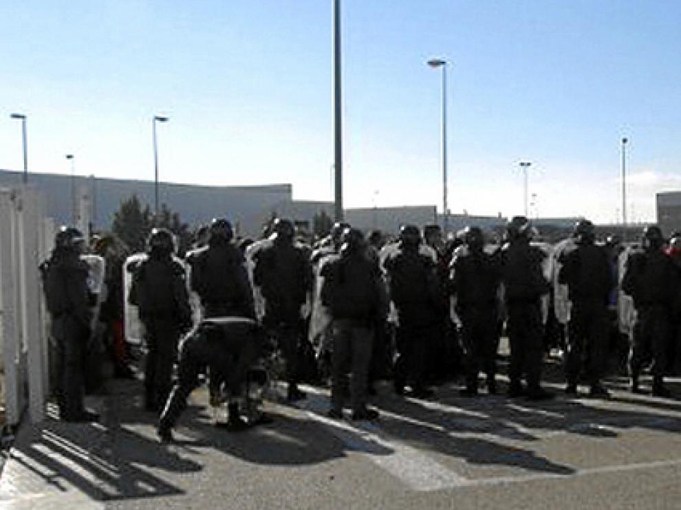 Agentes de la Guardia Civil, frente a los trabajadores concentrados ayer en la nave de Pedrola donde se guardaban asientos de Lear.