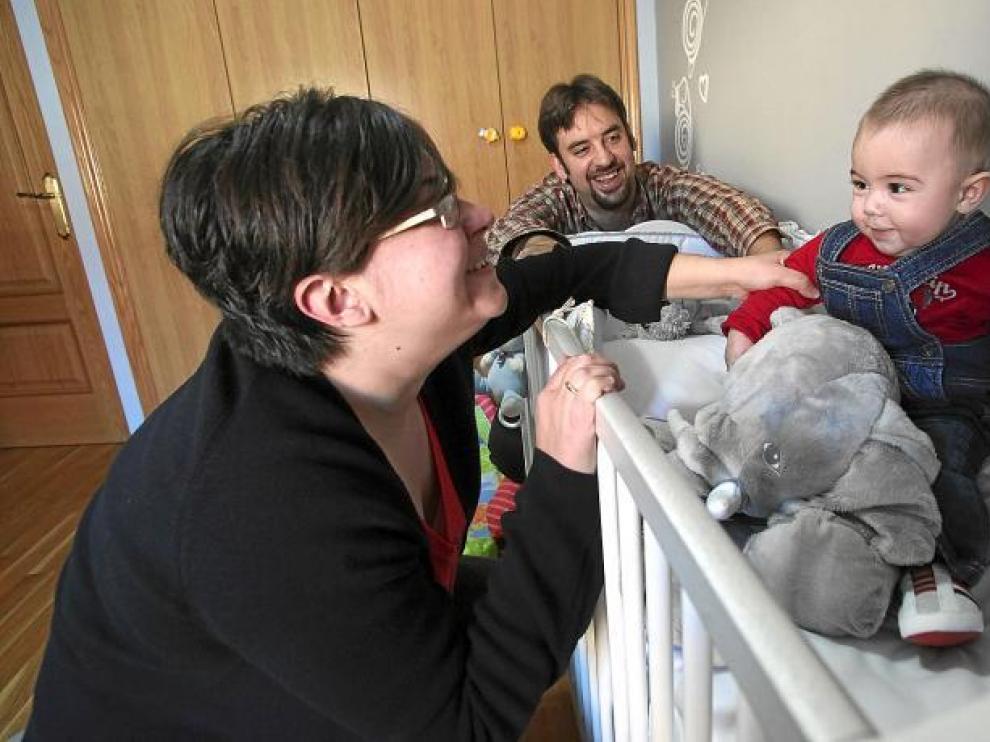 Juan, el bebé de cinco meses risueño y simpático, posa en su dormitorio junto a sus padres y con su peluche favorito.
