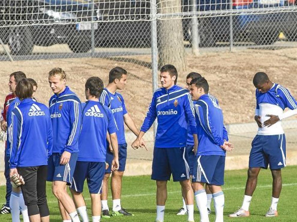 La plantilla del Real Zaragoza dialoga durante el entrenamiento del viernes.