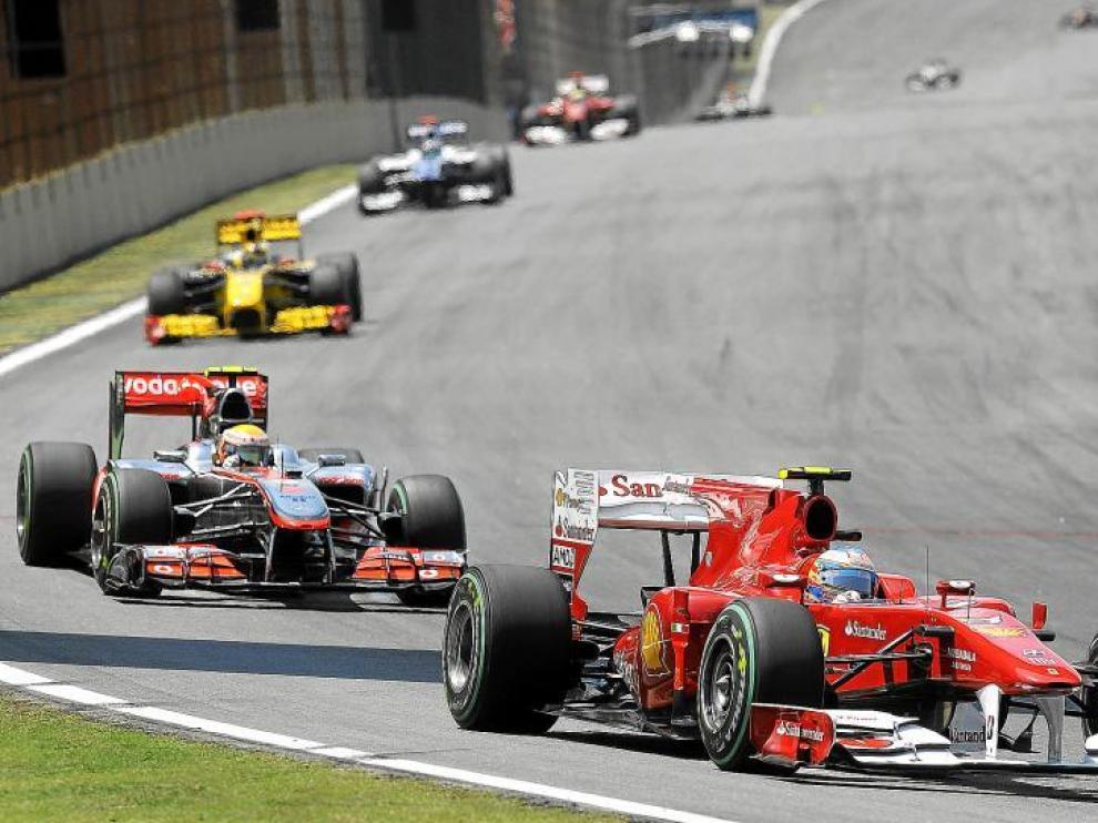 El piloto español Fernando Alonso (Ferrari), supera a su rival Lewis Hamilton (McLaren) durante el Gran Premio de Brasil.