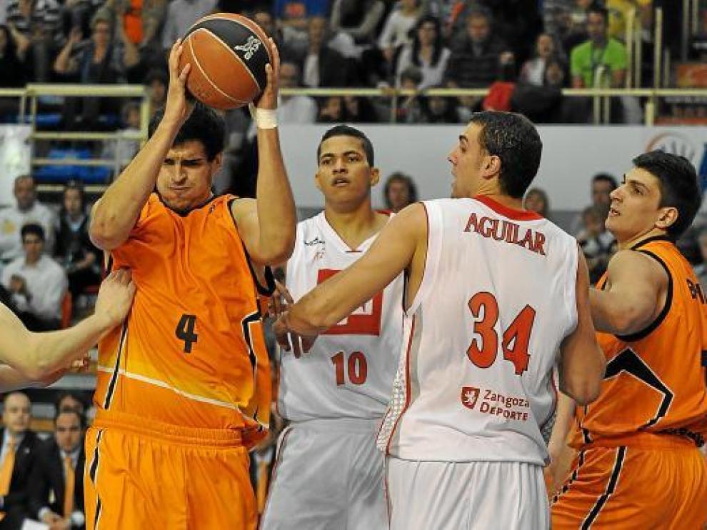 Mainoldi captura un rebote ante Hettsheimeir, Aguilar y Batista.