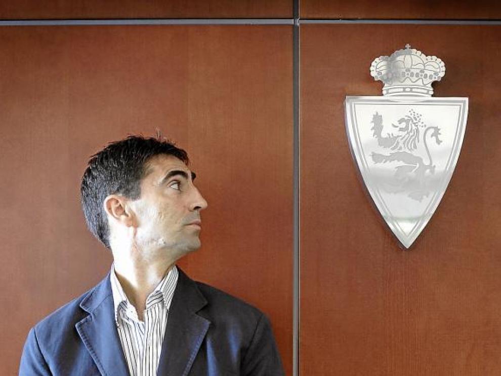 José Aurelio Gay, al lado del escudo del Real Zaragoza en la sede del club.