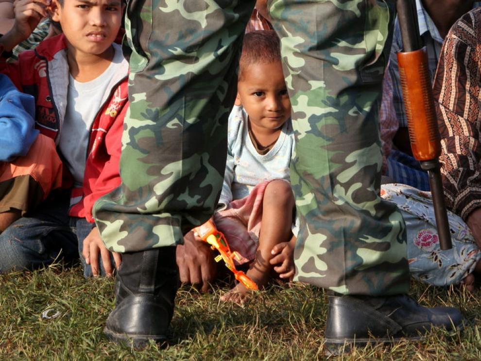 Un soldado tailandés vigila a refugiados birmanos que permanecen en la base de la policía fronteriza en Mae Sot (Tailandia)