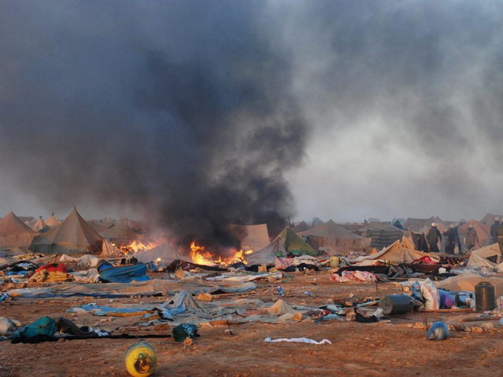 En el campamento desalojado arden en llamas algunas de las jaimas destruídas