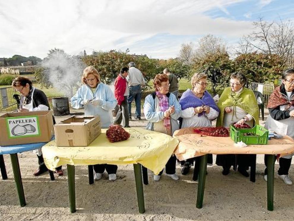 Unas mujeres preparan las castañas que se repartieron ayer gratis en el parque Oliver.