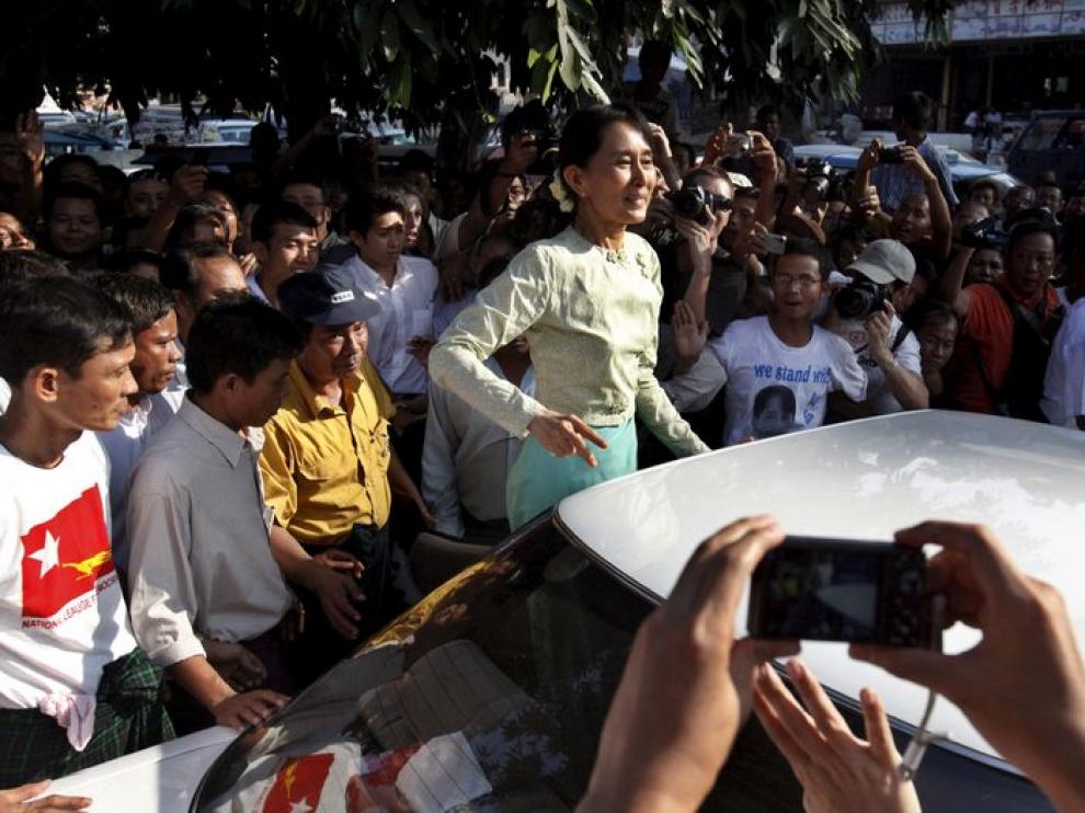 Aung San Suu Kyi saluda a sus seguidores a la salida de la sede de su partido, después de terminar su primer día de trabajo