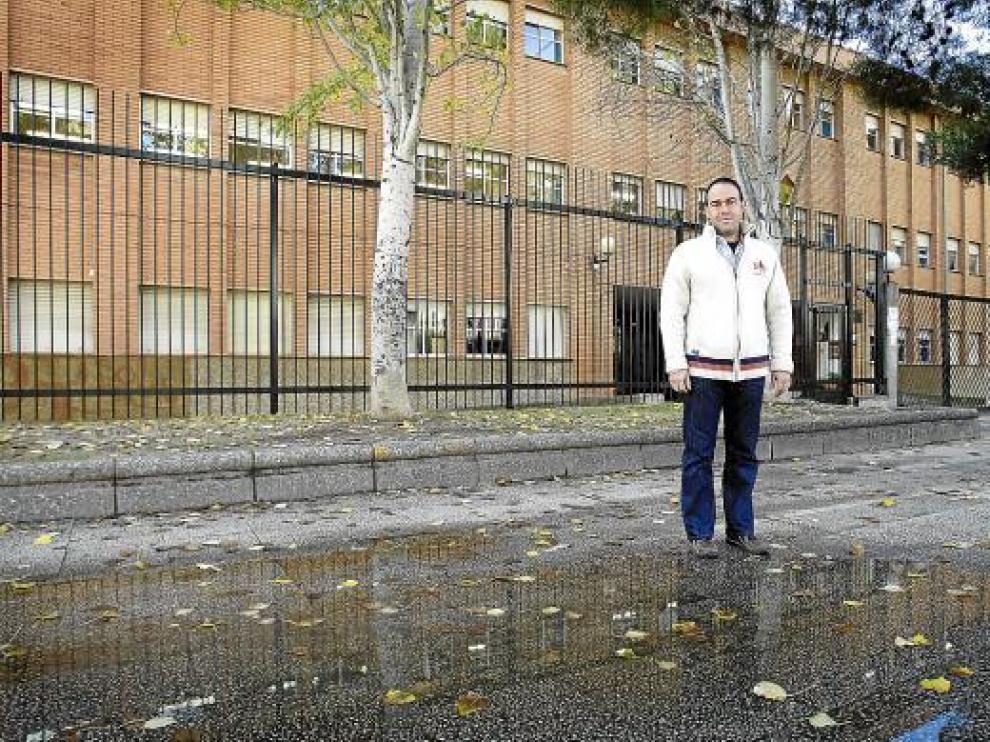 Francisco Sanz, vicepresidente de la Asociación de Padres, junto al charco en la puerta del colegio.