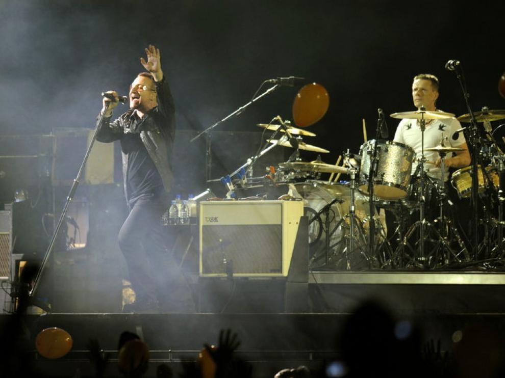 Bono, cantente de U2, con Larry Mullen tras él, durante una actuación en 2009