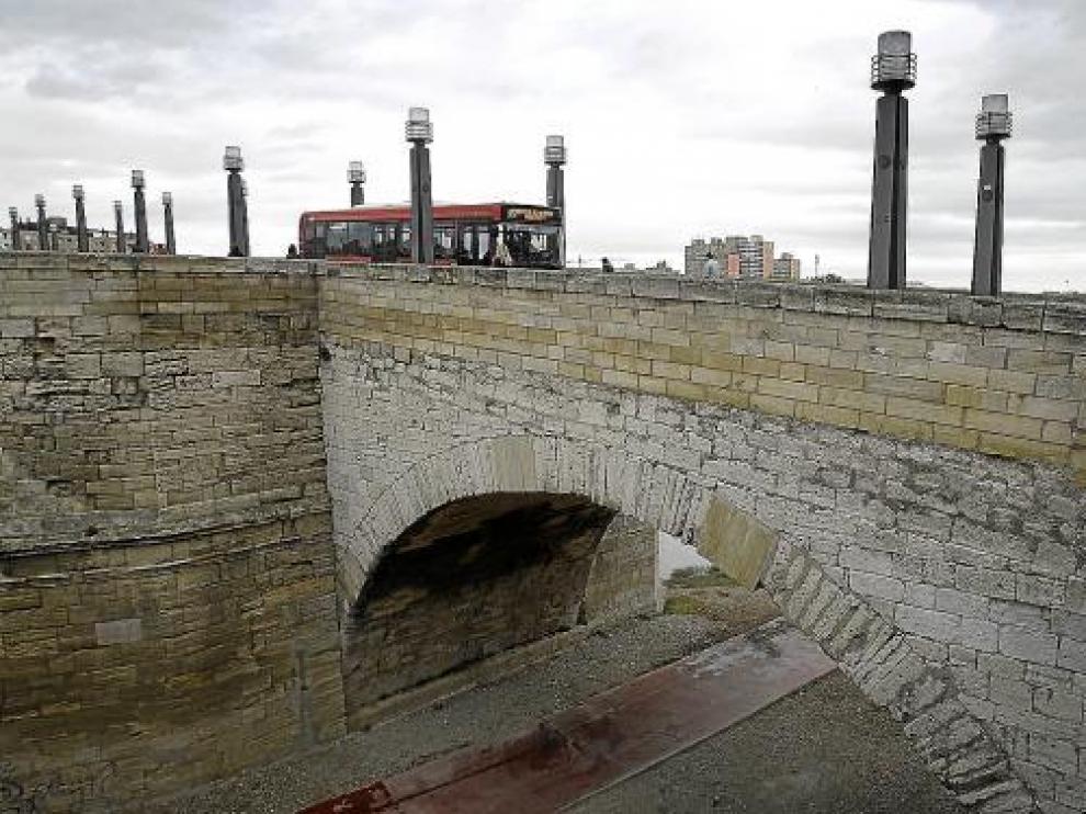 Un autobús atraviesa el puente sobre la arcada dañada por las grietas.