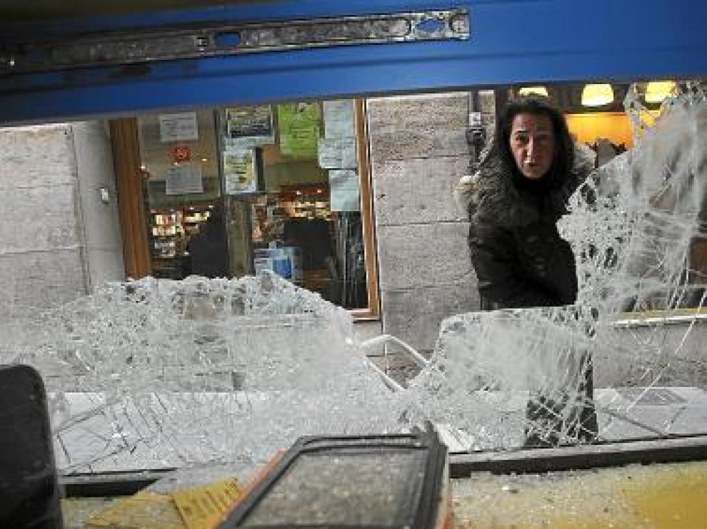 Una transeúnte observa el boquete abierto en el escaparate.