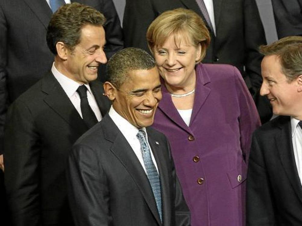 Sarkozy, Obama, Merkel y Cameron sonríen durante la foto de grupo de la cumbre de la OTAN.