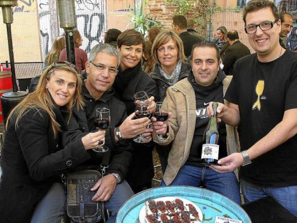 Clientes y el propietario de Bodegas Almau, brindando ayer con vino 'Beaujolais nouveau'.