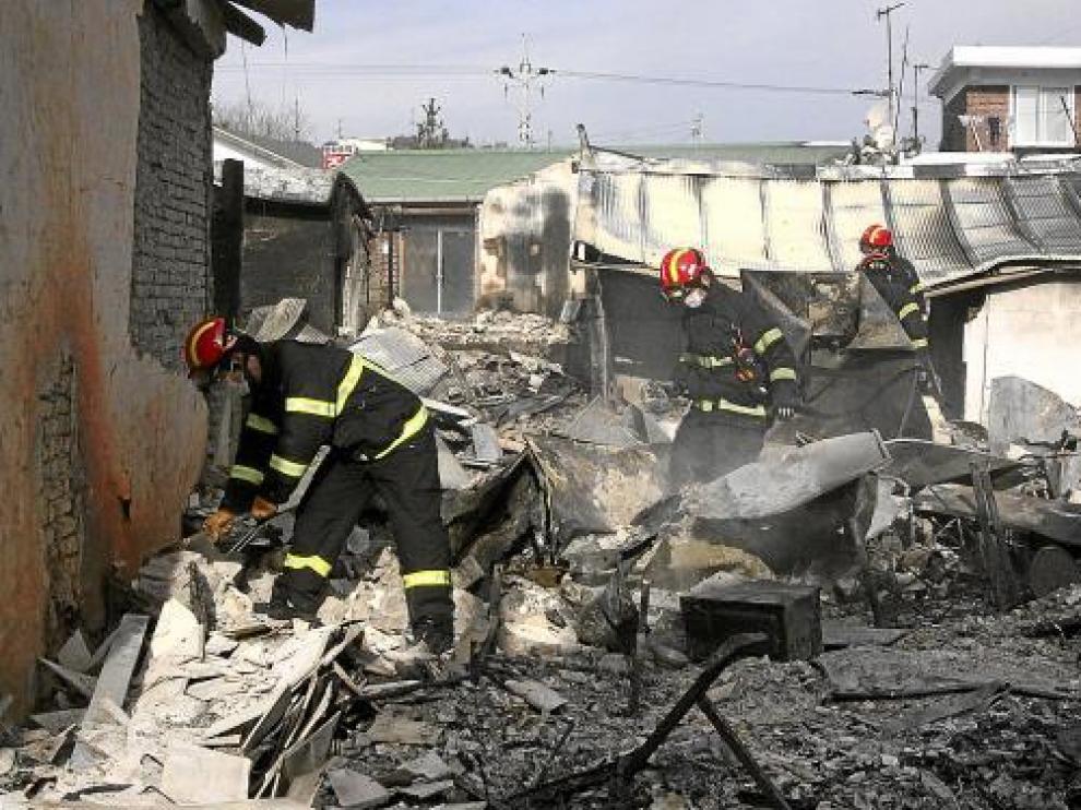 Miembros de emergencia, entre los restos de las casas destruidas, el martes en Yeonpyeong.