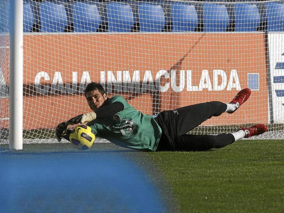 Andrés se estira para atajar un balón durante el entrenamiento que el Huesca hizo, ayer, sobre el césped de El Alcoraz.