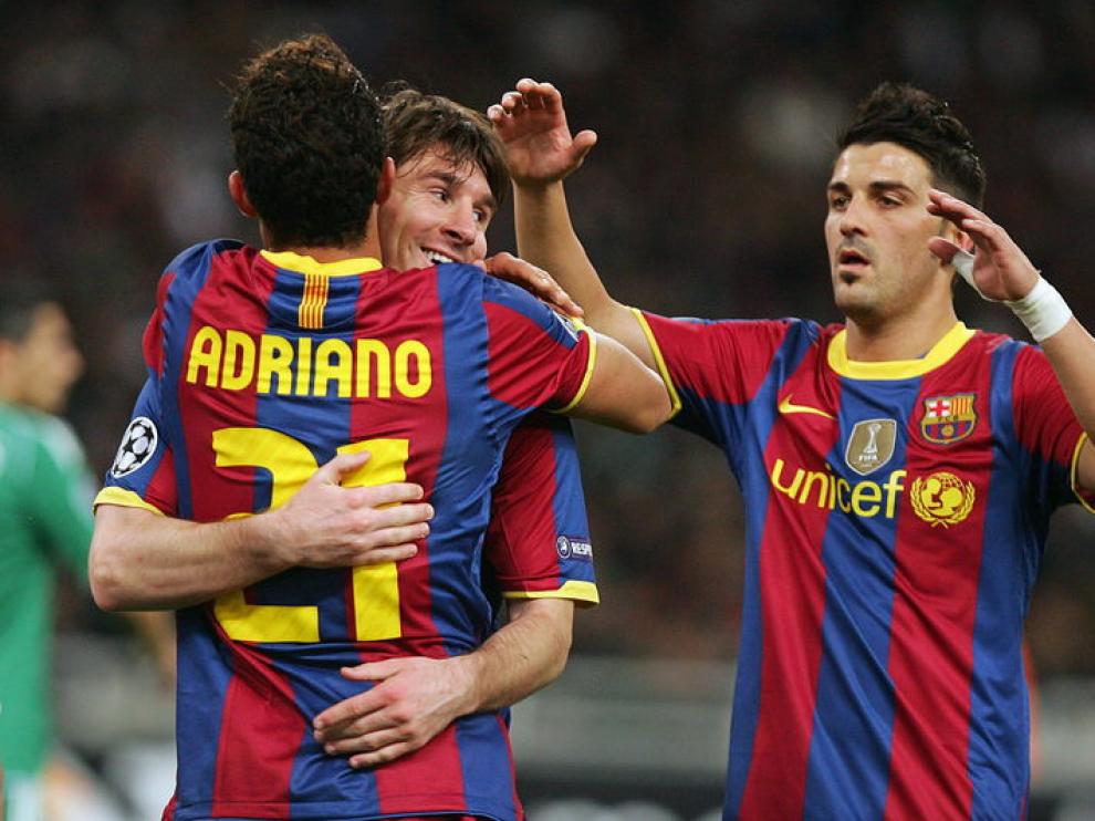 Messi se abraza con Adriano para celebrar uno de los goles del Barça
