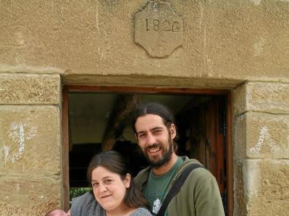 Carlota y Jorge, con el pequeño Diego, junto a su hotel rural.