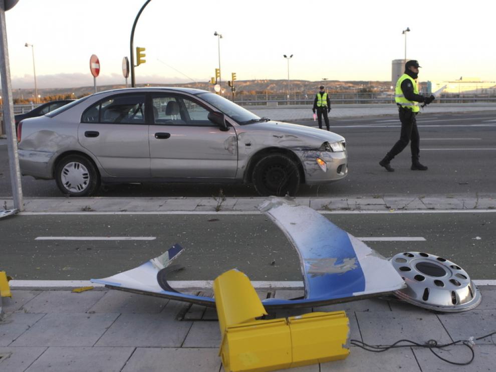 El coche implicado en el accidente, junto a varios objetos de la calzada destrozados