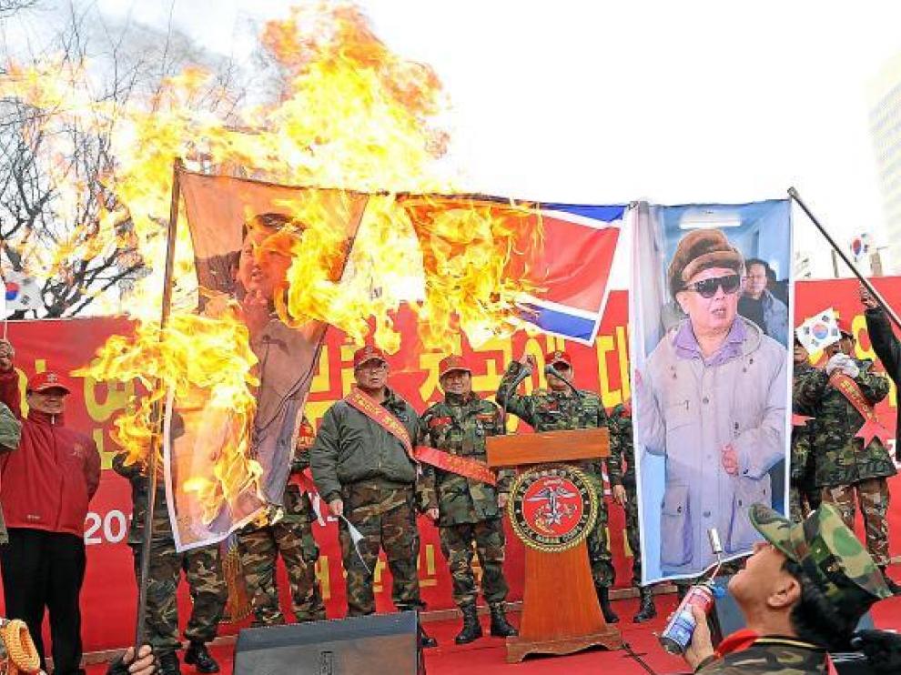 Veteranos militares surcoreanos queman banderas y fotos de los líderes norcoreanos, ayer en Seul.