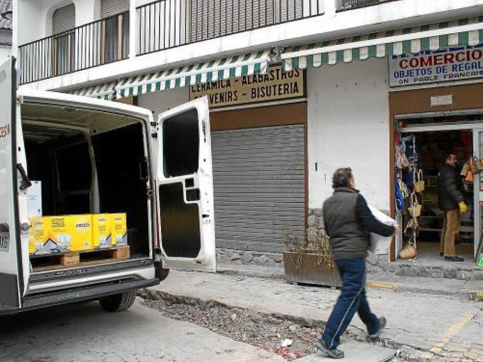 Los comercios de la plaza Mayor de Bielsa reponen sus estanterías para la reapertura.