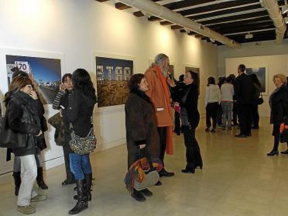 Varias personas contemplan la exposición en la inauguración.