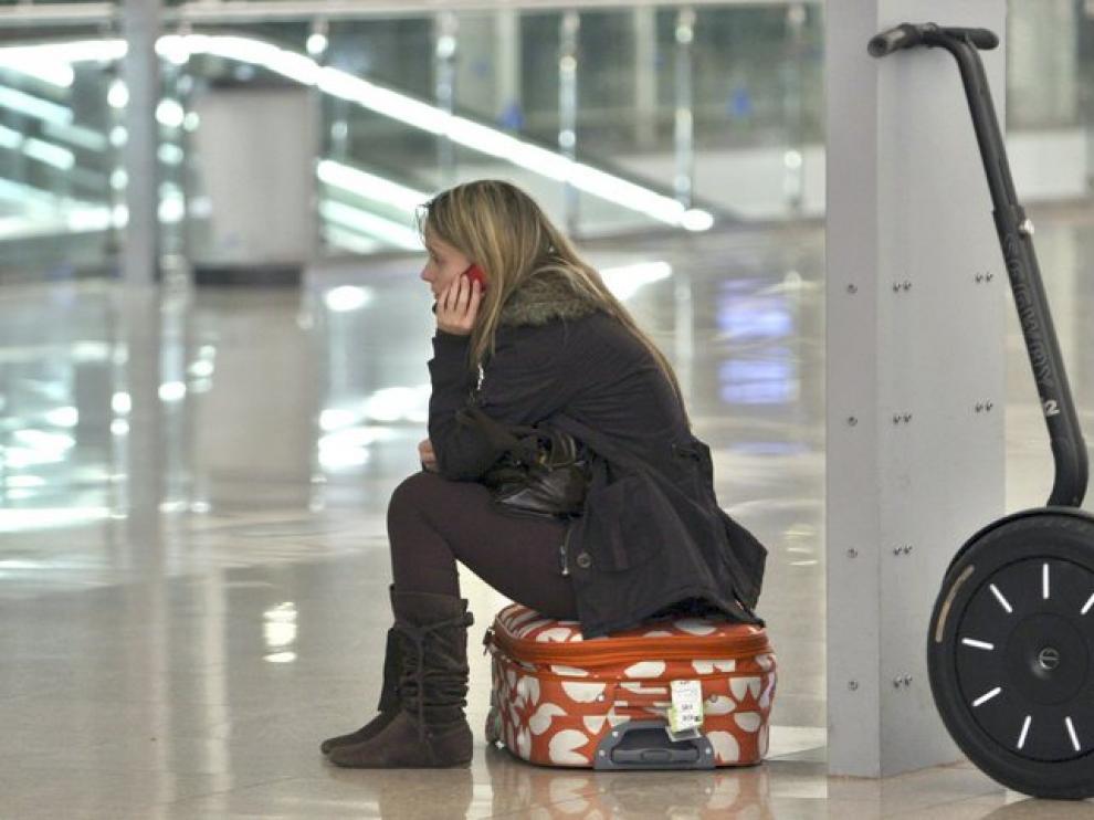 Una joven espera en el aeropuerto de Barcelona que se reanuden los vuelos