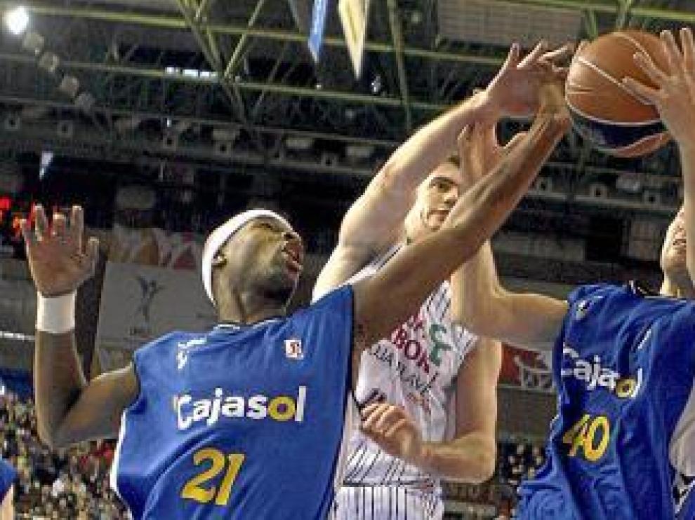 Barac intenta hacerse con el balón ante dos jugadores del Cajasol.