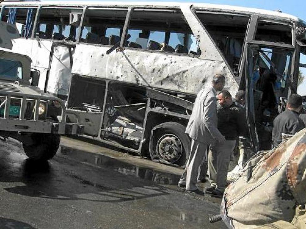 Iraquíes inspeccionan los restos de un autobús objetivo de un atentado en Bagdad, el sábado.
