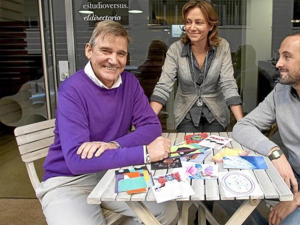 Javier Almalé y Nieves Añaños, del Estudio Versus, miran a José Carlos Aguelo, con algunas de las postales como testigo.