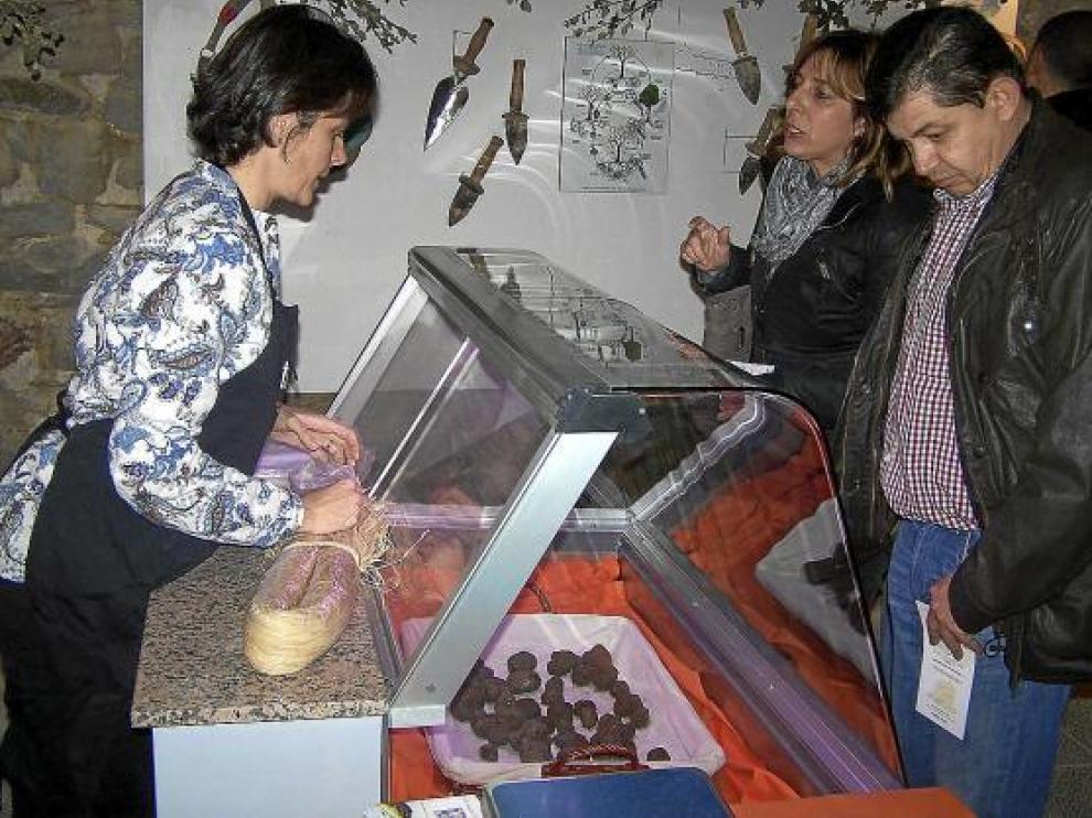Dos compradores se interesan por las trufas en un mostrador del mercado de Graus.