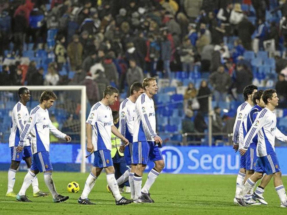 Los jugadores zaragocistas abandonan cariacontecidos el terreno de juego.