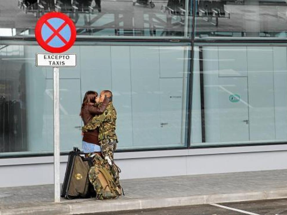 Un militar de la Brigada de Caballería Castillejos II besa a su pareja, ayer, en el aeropuerto de Zaragoza.