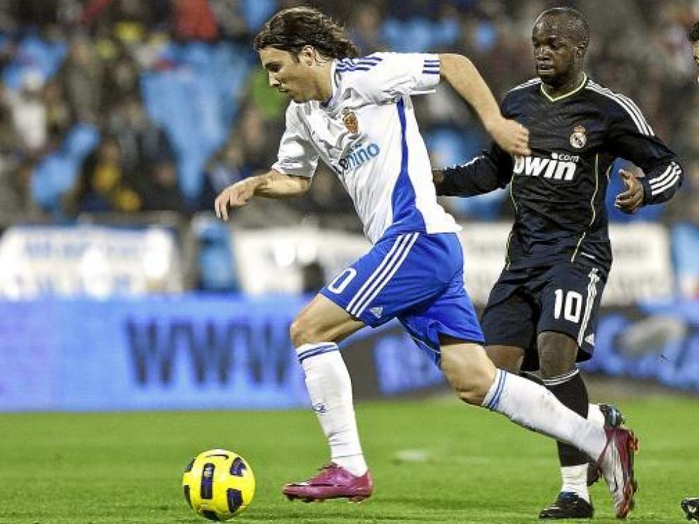 Bertolo avanza con el balón, perseguido por Arbeloa y Lass.