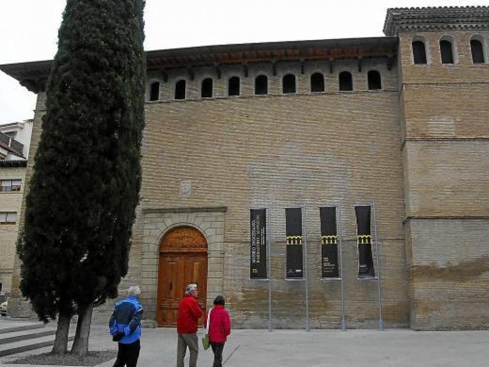Varias personas pasan junto al museo, que conserva el aspecto exterior de estilo gótico aragonés.