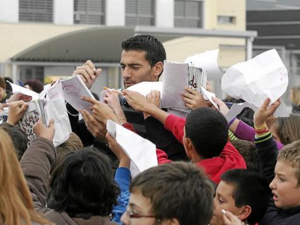 Roberto García firma autógrafos entre una nube de niños.
