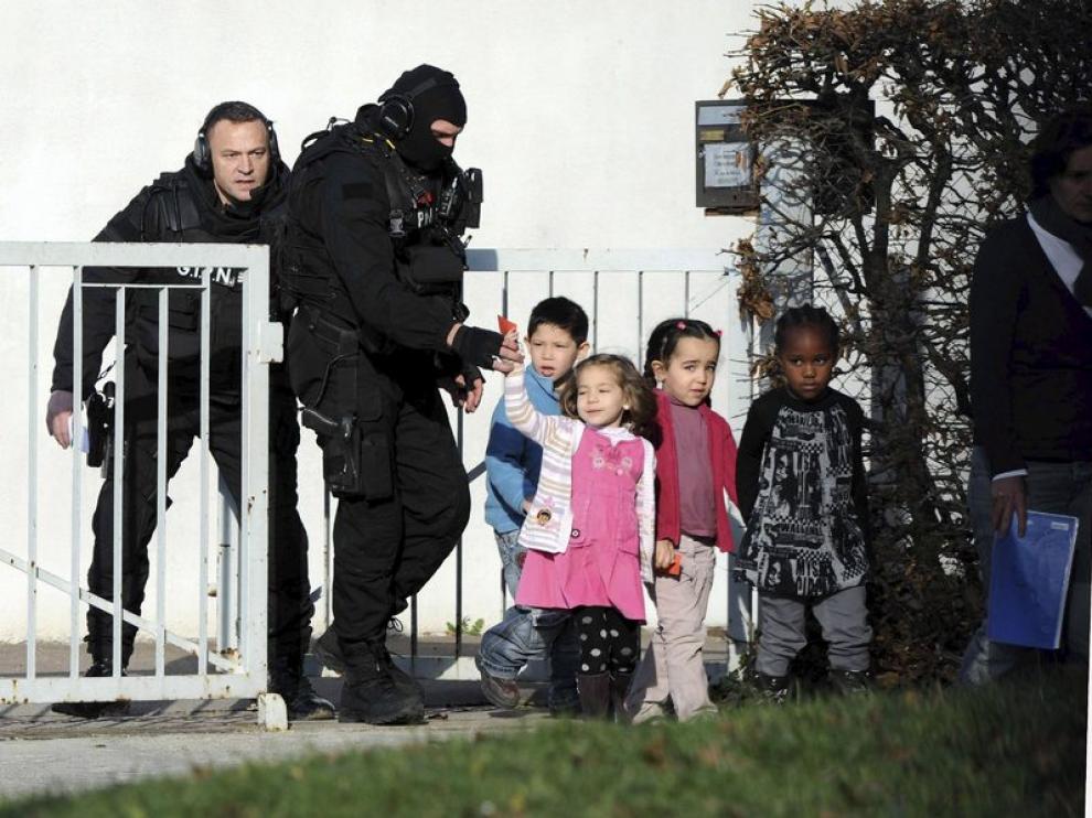 Policías acompañan a varios niños de un colegio de Besançon, en Francia, donde acabó felizmente el secuestro de una clase