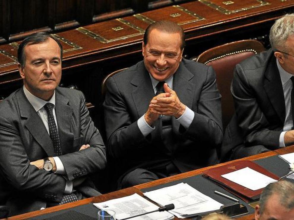 Berlusconi, flanqueado por sus ministros de Exteriores, Frattini, y de Economía, Tremonti, aplaudiendo ayer en el Congreso italiano.