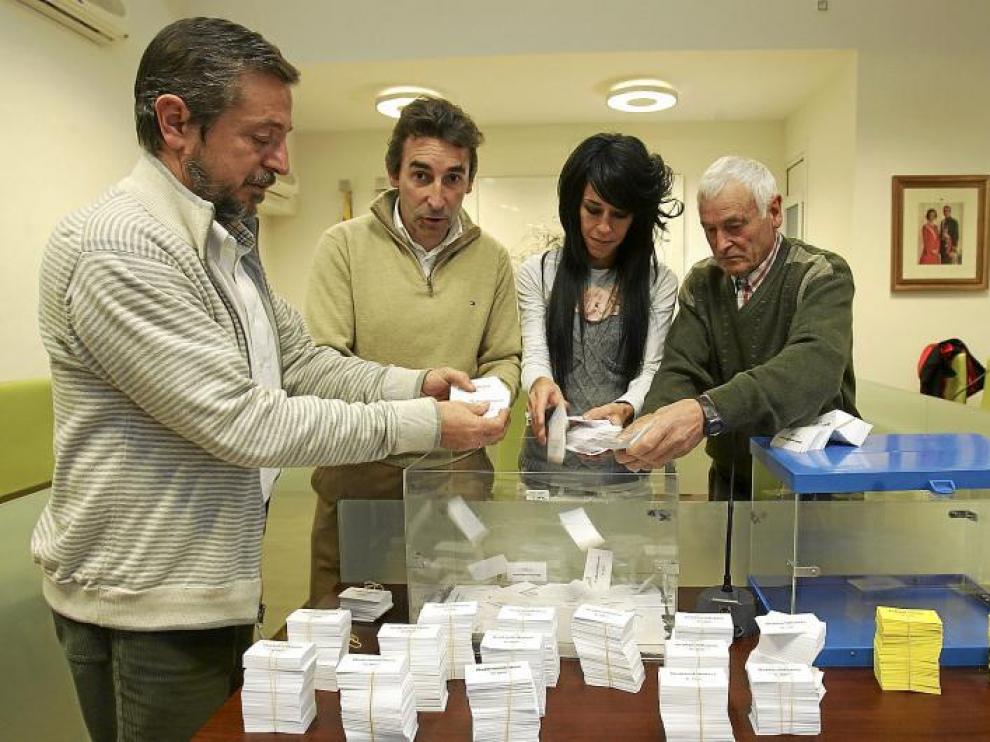Momento de la introducción de las papeletas con los números en las urnas preparadas para el sorteo.